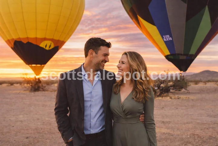 hot air balloon floating over Sonoran Desert at sunrise near Scottsdale Arizona with saguaro cacti below romantic couple